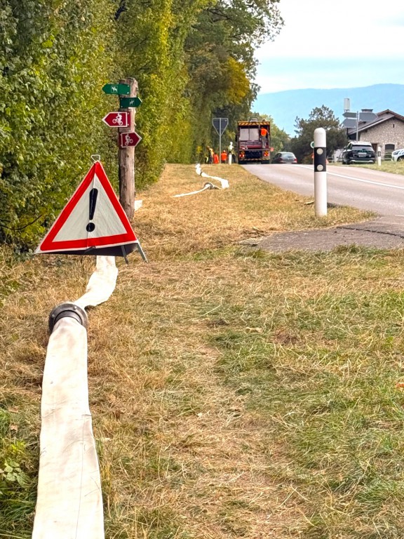 Photo du déploiement de l a conduite de secours, en bordure de route sur la route de la Cézille